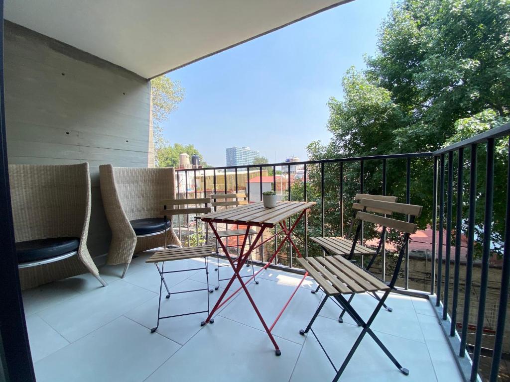 墨西哥城Terraza gran vista pegado a la condesa 2BR的阳台的天井配有桌椅