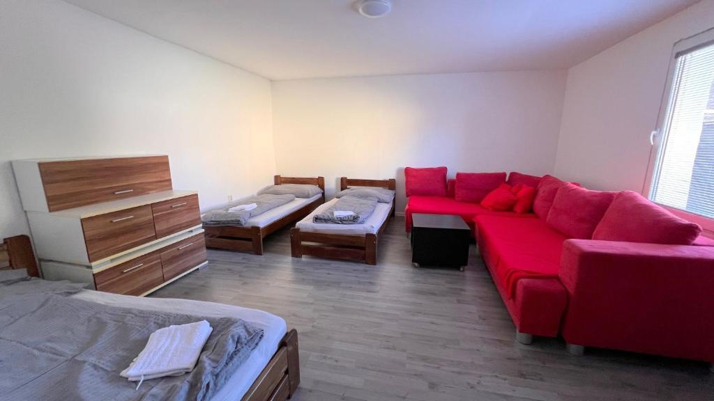 塞内奇Apartmánový dom Most pri Bratislave的客厅配有红色的沙发和床。