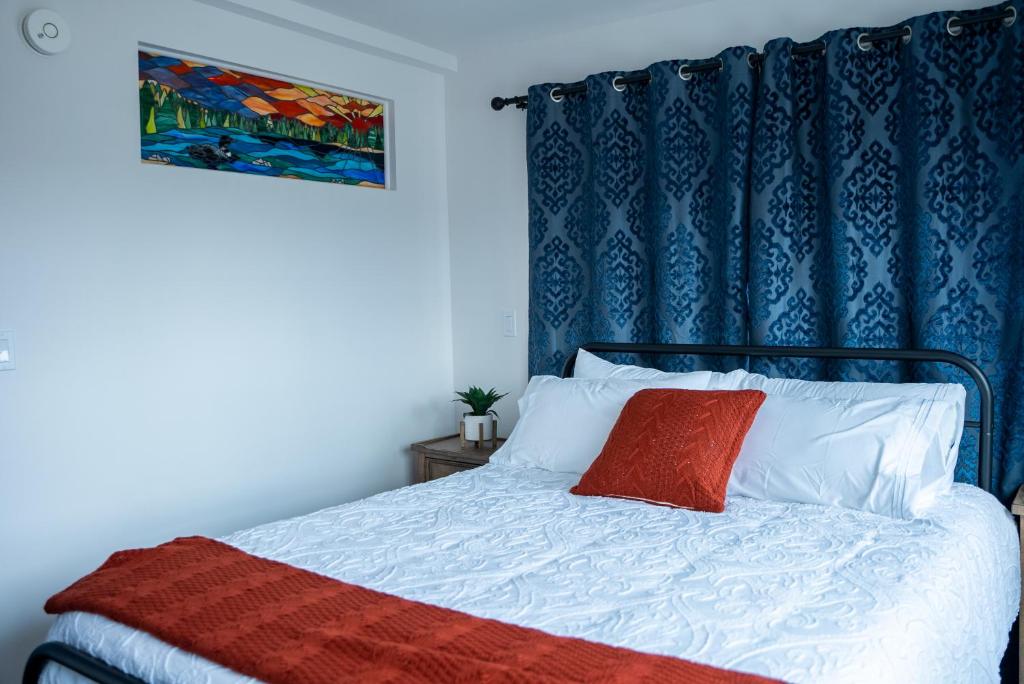 帕尔默Vasanoja Suite 102, Hyland Hotel的一间卧室配有一张蓝色窗帘的床