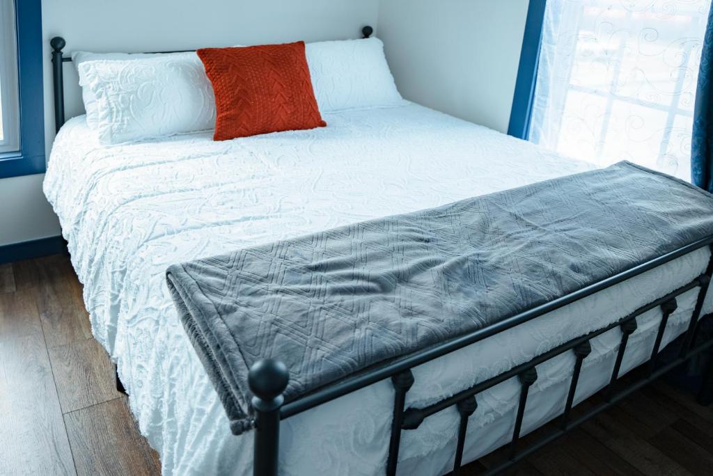 帕尔默Van Wormer Room 201, Hyland Hotel的一张带白色棉被和橙色枕头的床