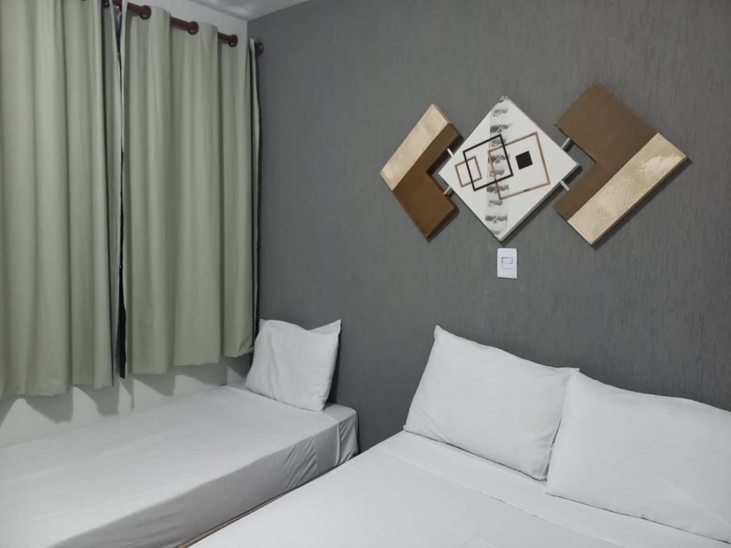巴乌鲁Alliance Hotel的两张睡床彼此相邻,位于一个房间里