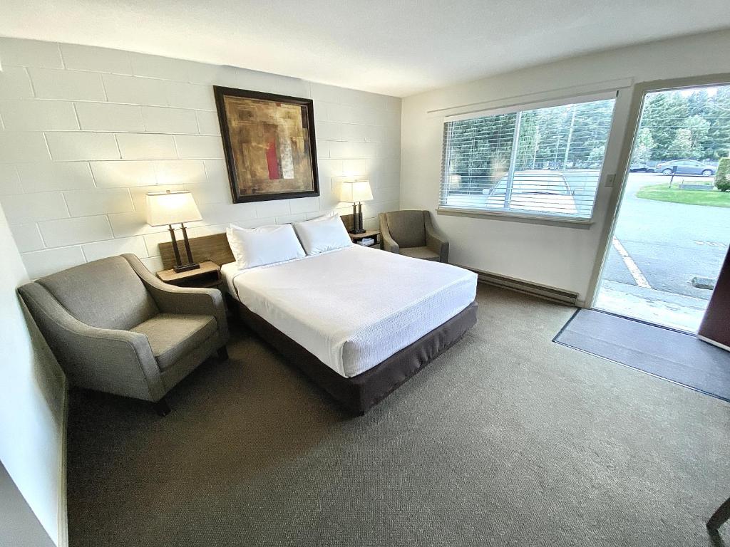 帕克斯维尔杨梅丛汽车旅馆的卧室配有床、椅子和窗户。