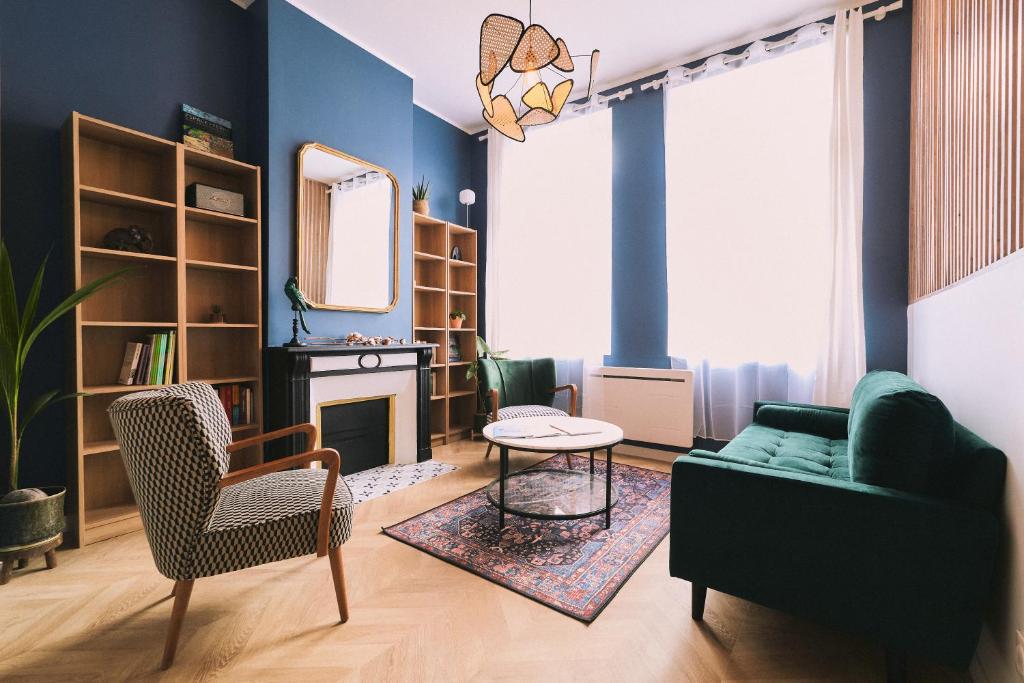 亚眠La Maison Des Petits Sablon的客厅拥有蓝色的墙壁和绿色的沙发