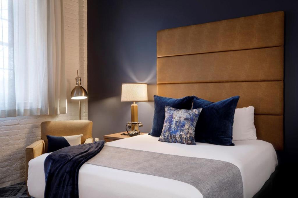 威奇托老城区酒店的一间卧室配有一张带蓝色枕头的大床