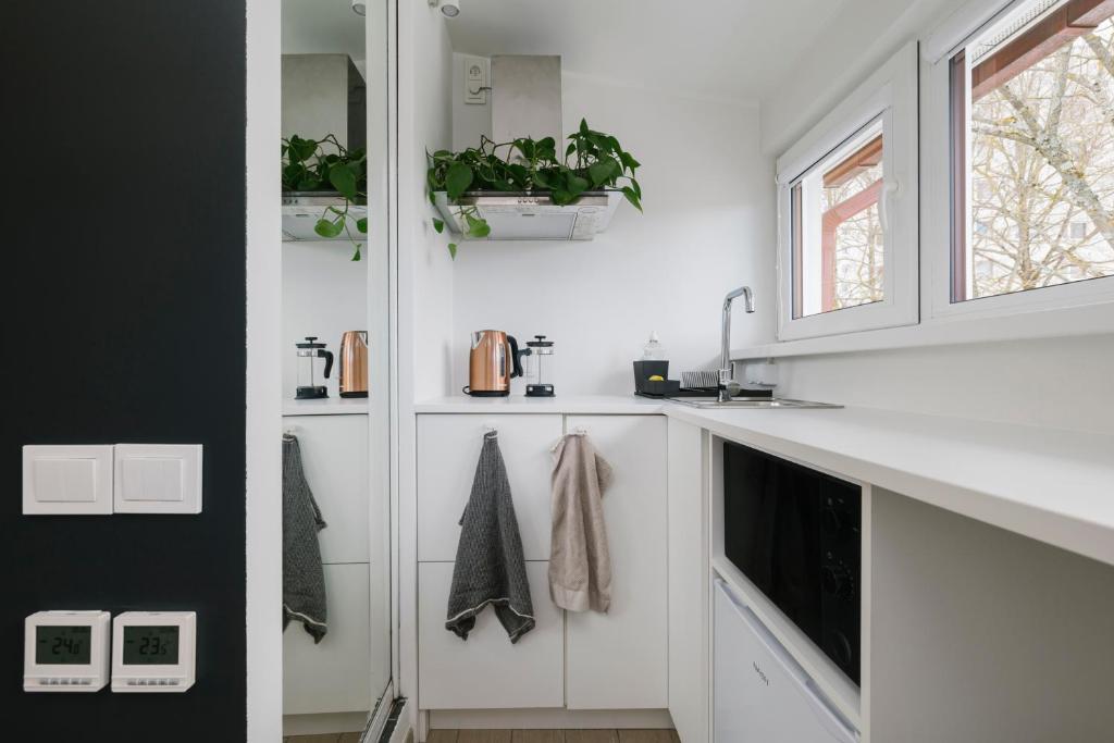 塔林Apartment for one - grey的白色的厨房配有白色橱柜和窗户