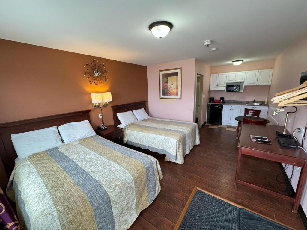 CochraneTravel Inn Cochrane的酒店客房带两张床和厨房