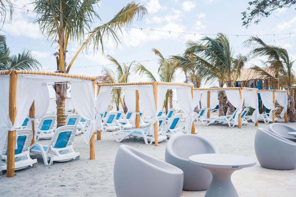 蓬塔查梅Sanctuary by Playa Caracol Residences的海滩上的一组桌椅