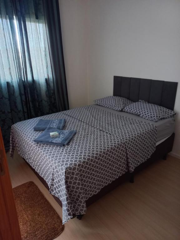 ParanoáApartamento的一间卧室配有一张带黑白色床罩的床。