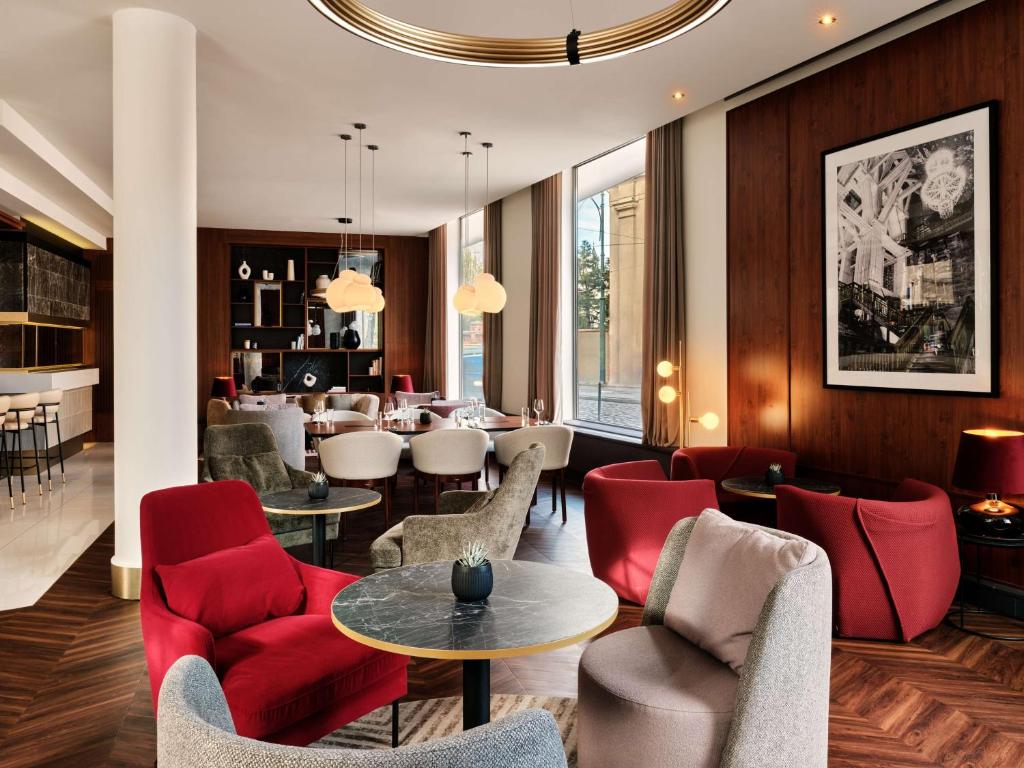克拉科夫克拉科夫丽笙大酒店的酒店大堂设有红色椅子和用餐室
