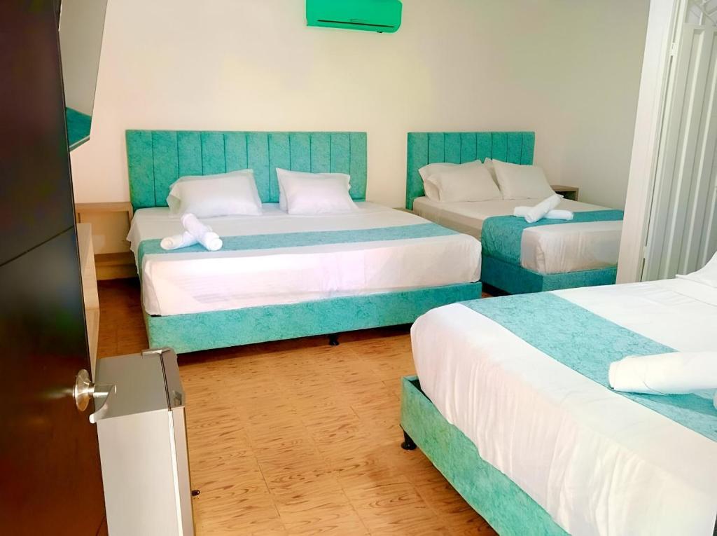 里考尔特Hotel Pallara Campestre的一间卧室配有两张蓝色和白色的床