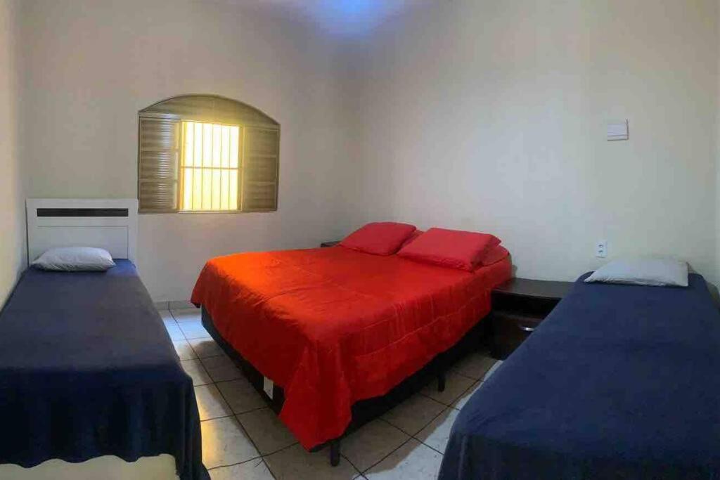 里贝朗普雷托Casa de Férias 1purbana的一间卧室配有两张床和红色毯子