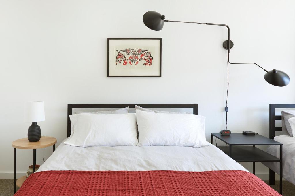 安克雷奇Snob Hollow Inn Downtown Anchorage的一间卧室配有一张带红色毯子的床