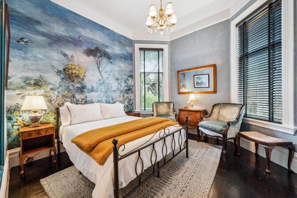 旧金山Historic & Charming Victorian Home Sleeps 11的卧室配有一张床,墙上挂有绘画作品