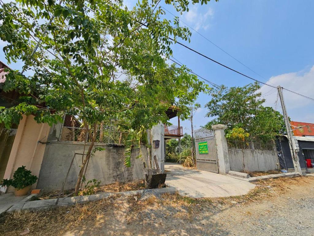 金边SothAnna Khmer House的街道旁的一座建筑,有栅栏和树