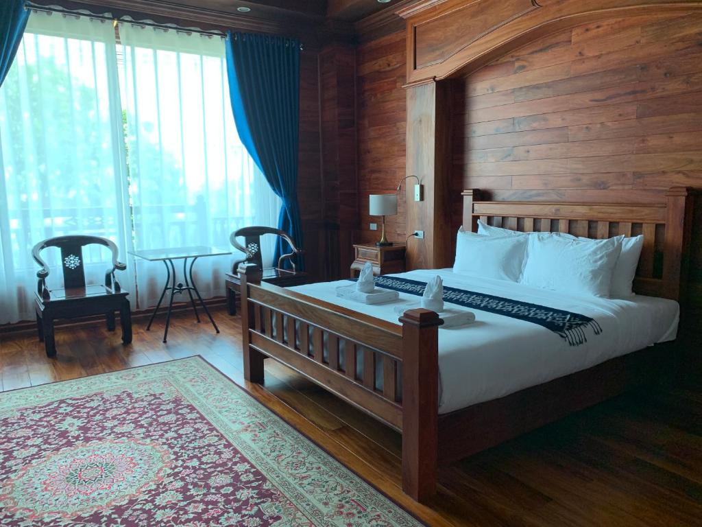 沙湾拿吉HotelLaoMixay的一间卧室设有一张带木墙的大床