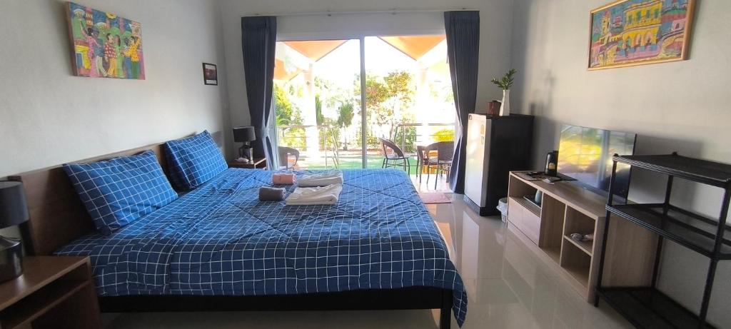 班佩Yawee & Jo Guesthouse的一间卧室配有蓝色的床和电视