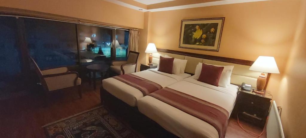 廷布Hotel Kisa Thimphu的一间设有大床和窗户的酒店客房