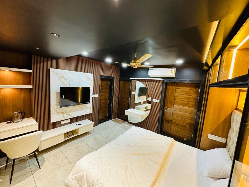 焦特布尔MG apartments的一间卧室配有一张床和一台电视,还设有一间浴室