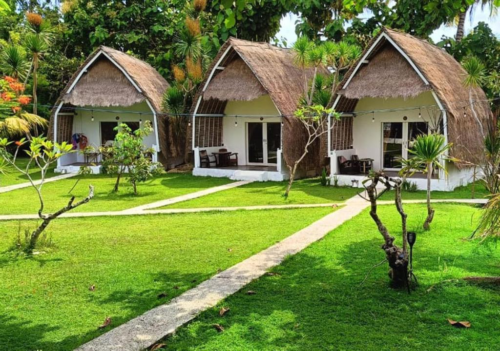 珀尼达岛合十礼简易别墅的绿色庭院内带2间小屋的度假村