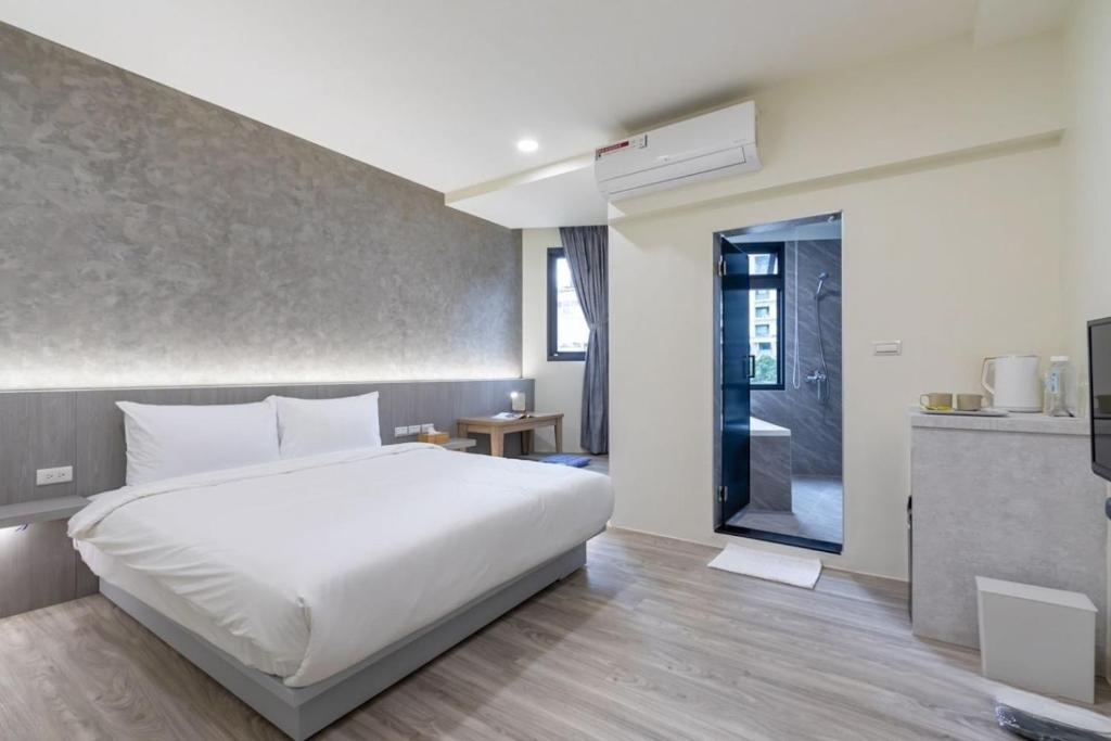 礁溪礁溪亞都溫泉旅店 Newly Renovated的一间带白色床的卧室和一间厨房