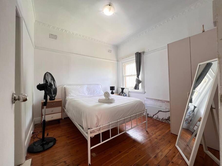 悉尼Budget 1 bedroom unit near Maroubra Beach的卧室配有白色的床和窗户。