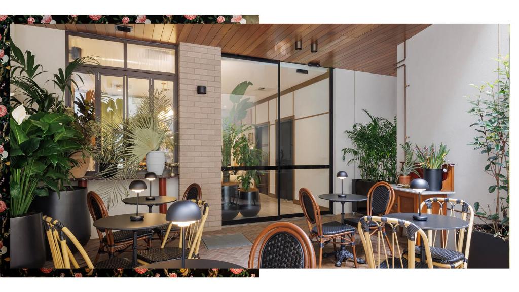 悉尼202 Elizabeth Hotel - The Oxford - Australia的一间设有桌椅的餐厅,种植了植物