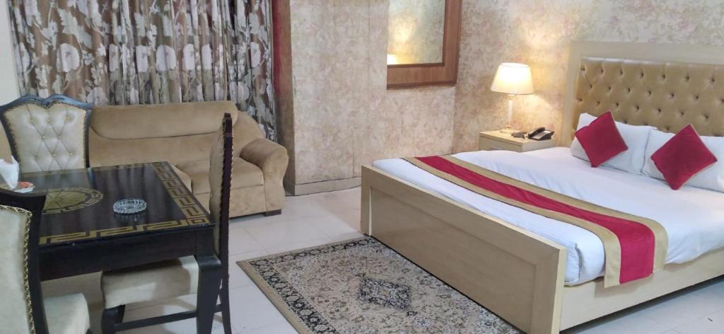 拉合尔Premier Inn Davis Road Lahore的卧室配有1张床、1张桌子和1把椅子
