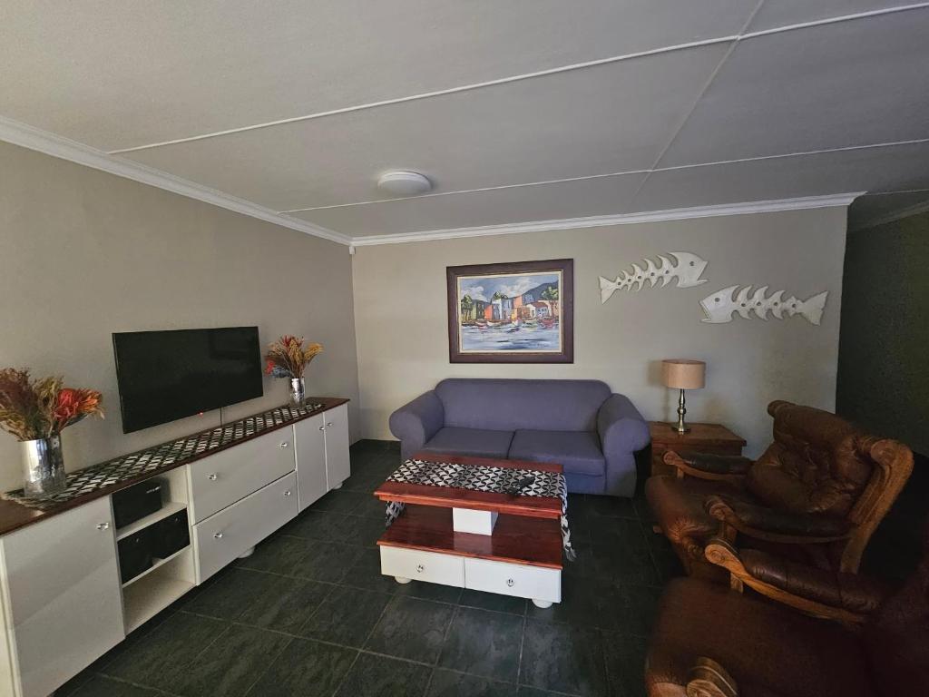 昆斯敦Amberdale Estate Self Catering的客厅配有紫色沙发和电视