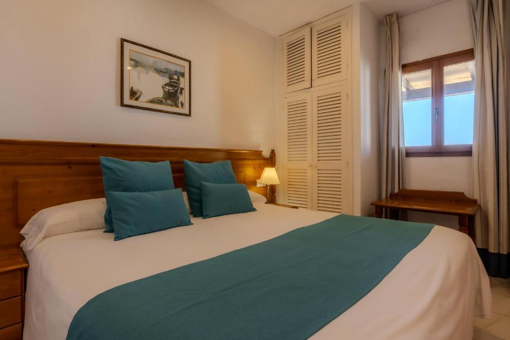 埃斯普霍斯桑威蓬塔俱乐部高级酒店的一间卧室配有一张带蓝色枕头的大床