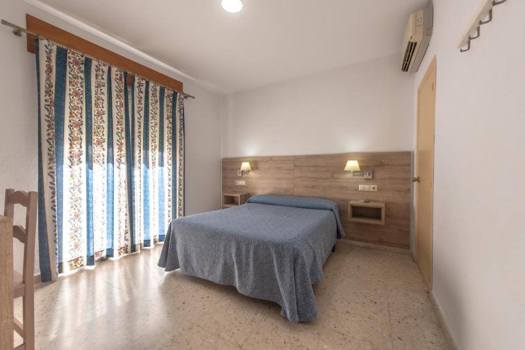 赫雷斯-德拉弗龙特拉圣安德烈斯酒店的一间卧室设有一张床和一个大窗户