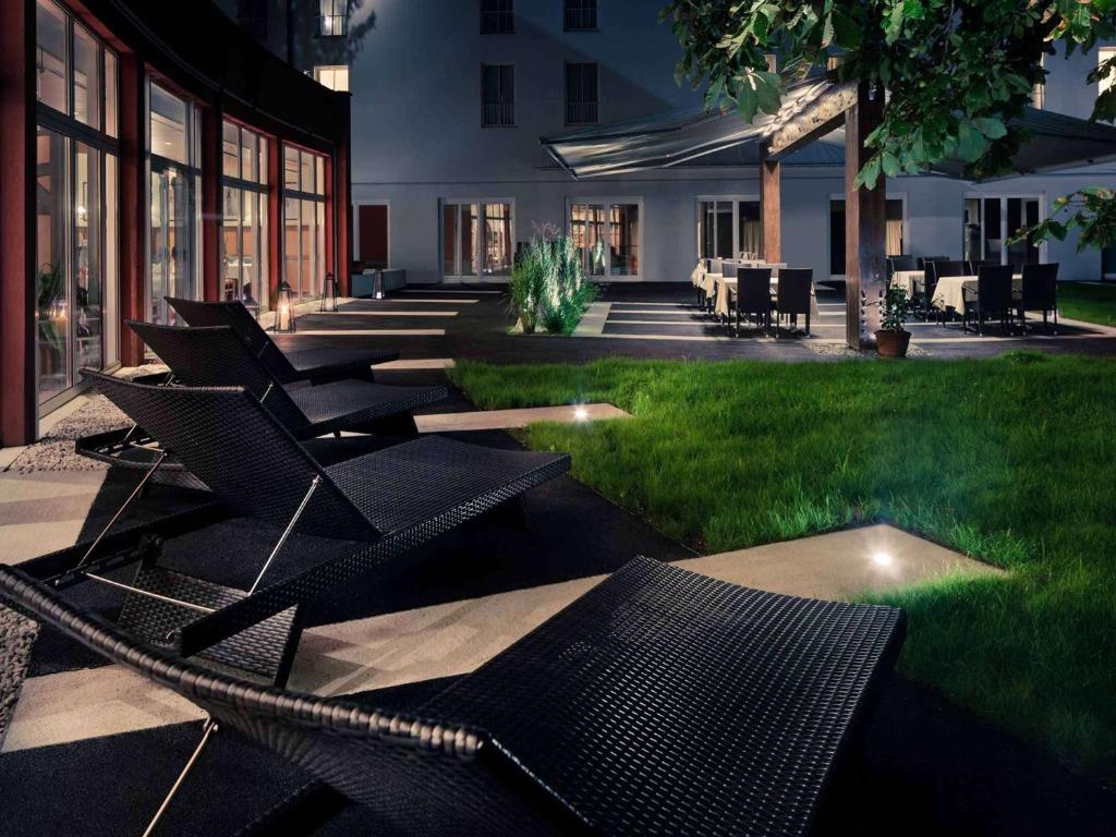 萨尔茨堡美居萨尔茨堡城市酒店的坐在庭院草地上的一组椅子
