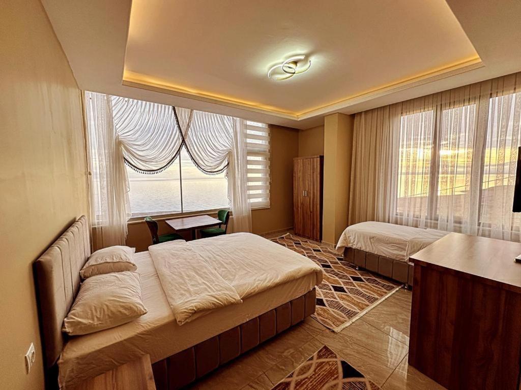 ErkizanAhlat 1071 Otel&Restaurant的一间卧室设有两张床和窗户。