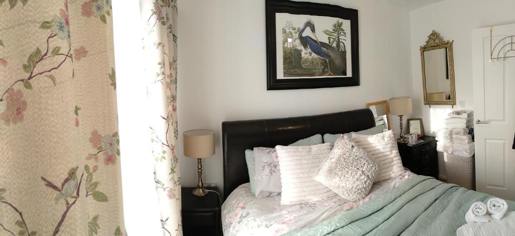 普雷斯科特House Rose 1的一间卧室配有一张带黑色床头板和白色枕头的床。
