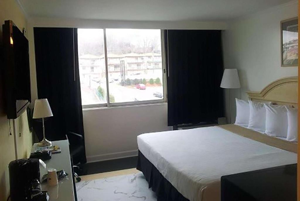 北卑尔根Ramada by Wyndham North Bergen的酒店客房设有床和窗户。