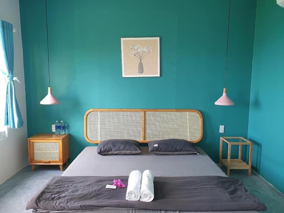 绥和市Kaktus home & kafe的一间卧室配有一张蓝色墙壁的床