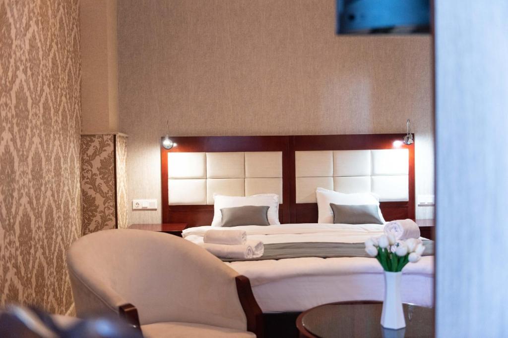 第比利斯Kraveli Hotel的卧室配有一张床和一张桌子及椅子