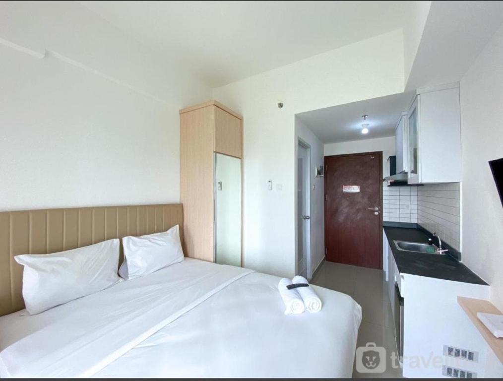 贝克西Capital O 93854 Apartemen Sayana By Sentra Jaya的卧室配有白色的床和水槽