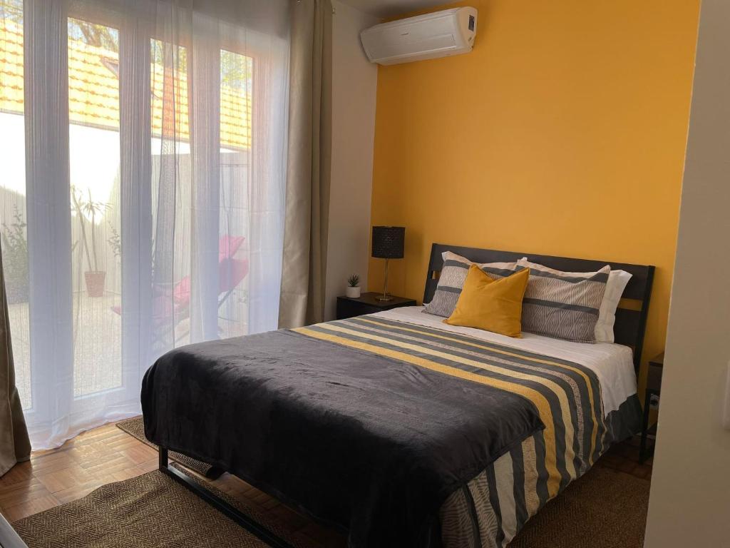 波尔图100康托斯住宿加早餐旅馆的一间卧室设有一张黄色墙壁和窗户的床