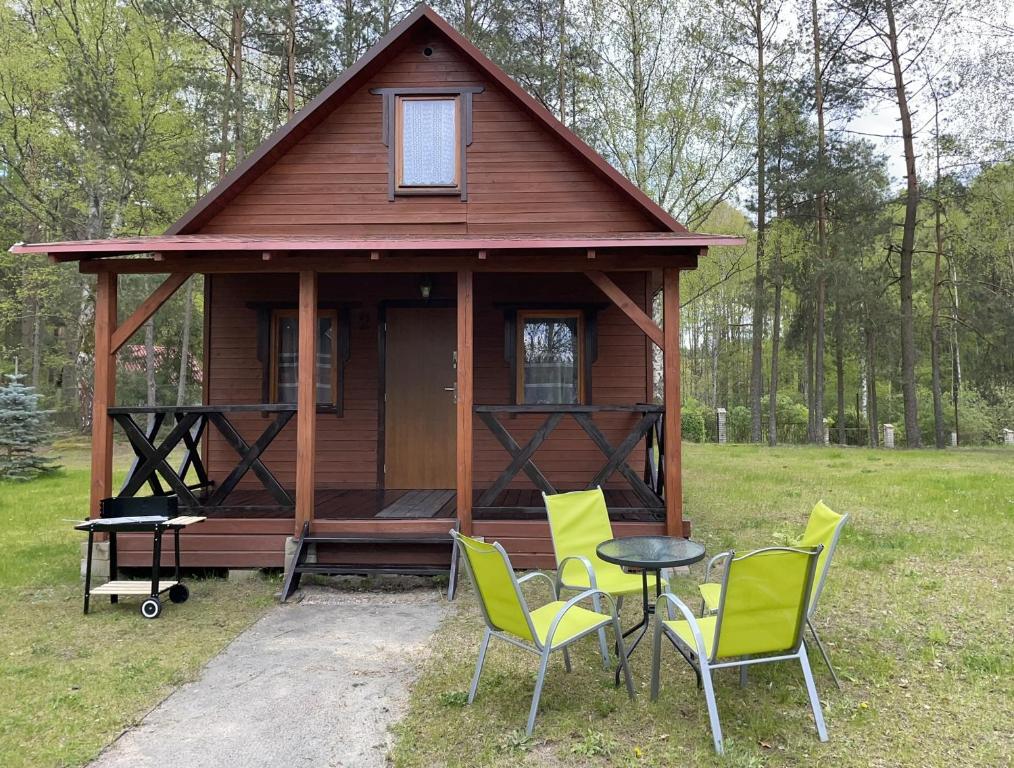 CieciorkaDomki Letniskowe Nad Jeziorem Kazub的小屋前方设有桌椅