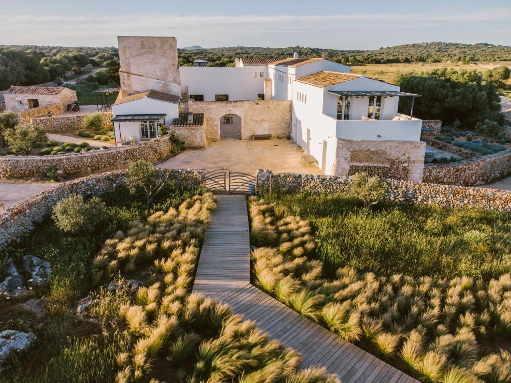 苏昂博Torre Vella Fontenille Menorca的享有带木制走道的房屋的空中景致
