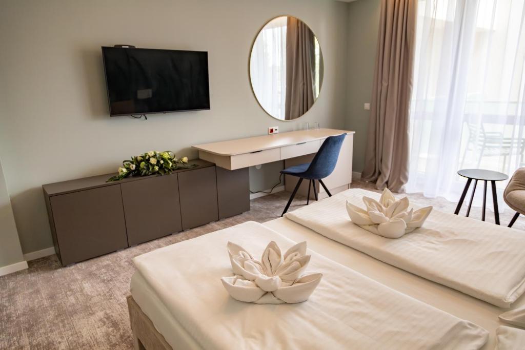 豪伊杜索博斯洛Hotel Atlantis Medical, Wellness & Conference的酒店客房设有两张床和电视。