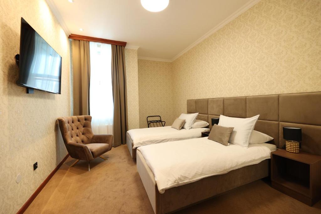 巴尼亚卢卡维多维奇酒店的酒店客房,配有两张床和椅子