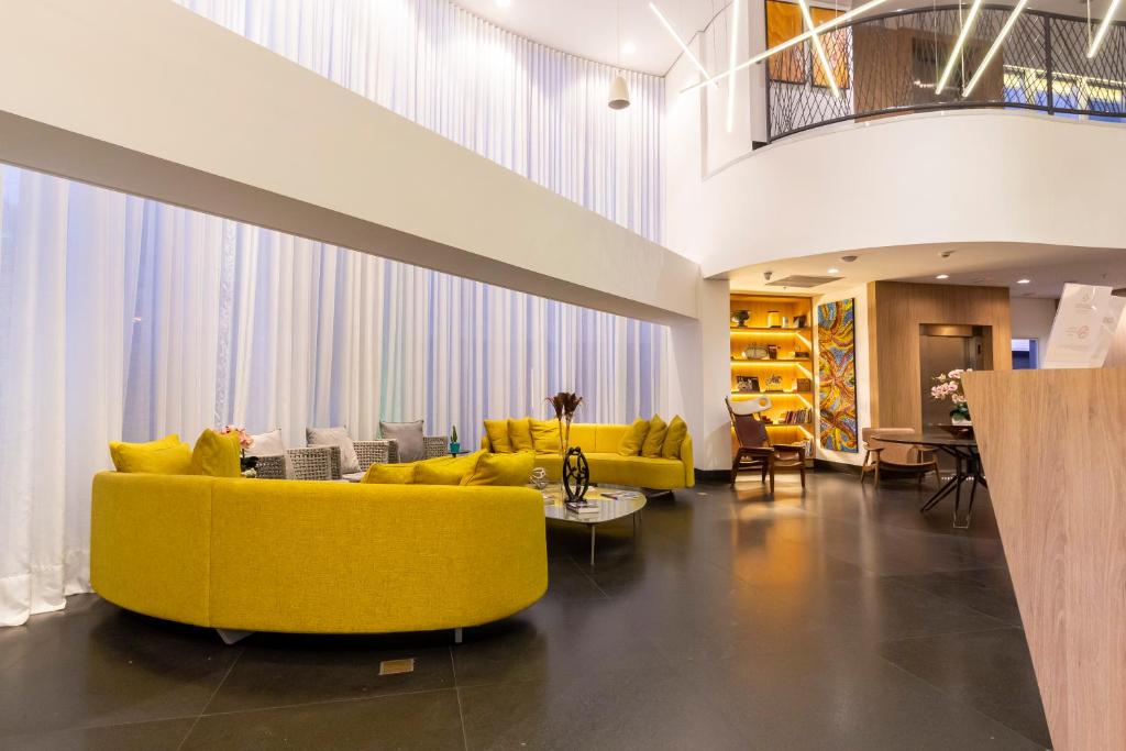 普雷图河畔圣若泽Hotel Cassino Tower São José do Rio Preto by Nacional Inn的客厅配有黄色的沙发和椅子