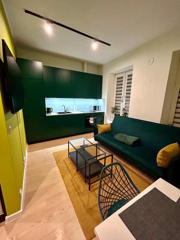 卢布林Apartment Targowa L7的一间带绿色沙发的客厅和一间厨房