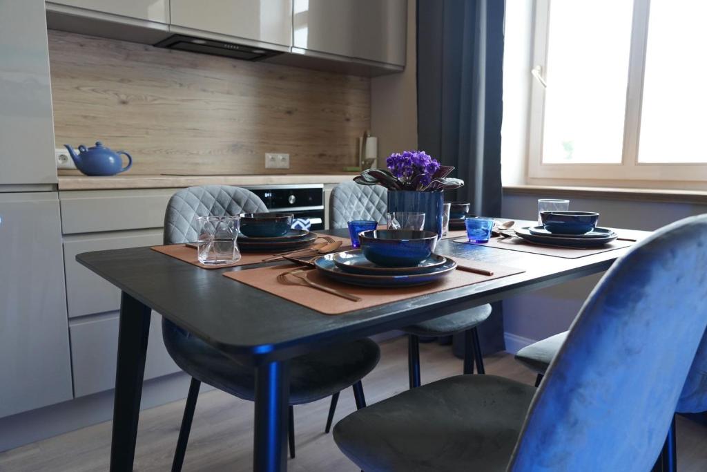 利耶帕亚Giertmaņa apartamenti的厨房配有带盘子和碗的桌子