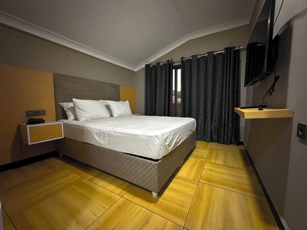 基加利acacus hotel的一间卧室配有一张床和一台电视