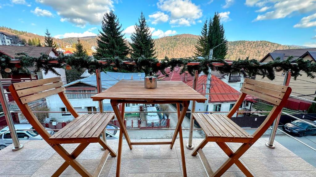 布什泰尼Valea Albă View - SELF CHECK-IN的阳台上配有一张木桌和两把椅子