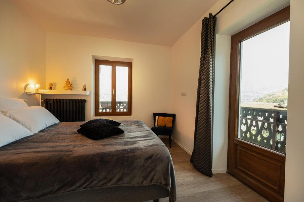 VenthonChalet les Myrtilles的一间卧室设有一张床和一个大窗户