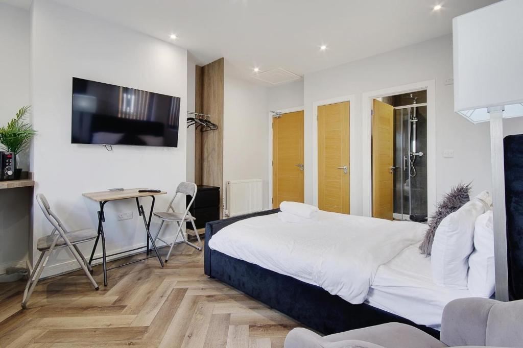 伯恩茅斯Wimbourne Road Apartment 1的一间卧室配有一张床、一张桌子和一台电视。