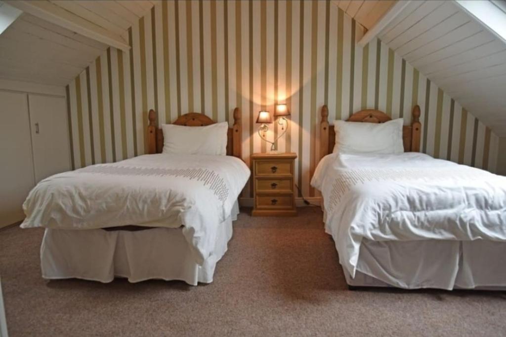 基利贝格斯Mardan House B&B的一间卧室配有两张带白色棉被的床